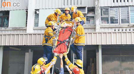 消防員合力將跳樓婦人抬落地下送院。	（李豪杰攝）