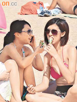 夏日炎炎，女泳客吃甜筒以解酷熱之苦。	（羅君豪攝）
