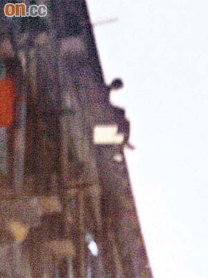 失戀青年危坐在八樓天台石壆邊緣，與救援人員對峙，其後跳下身亡。	（王偉安攝）