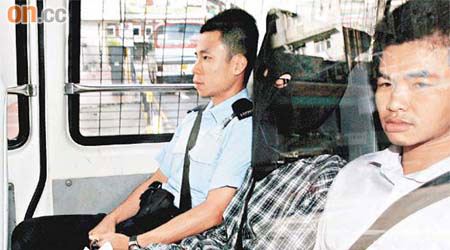 十五歲被告身穿醫院提供的病人服，由警方押解到荃灣法院提堂。	（蘇文傑攝）