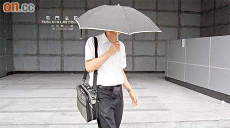 何廣明被控非禮罪，昨應訊後用傘遮臉離開。