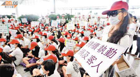 港龍空勤人員手持橫額及標語在機場內遊行抗議。	（高嘉業攝）