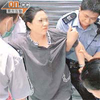 涉嫌將女兒「剝光豬」的婦人被警方拘捕時手舞足蹈。