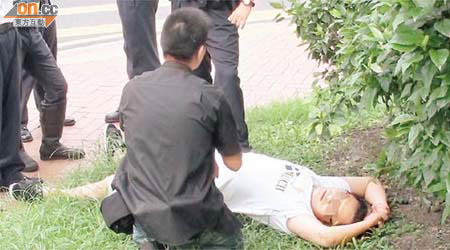 滿身酒氣司機躺臥草地，對警員詢問愛理不理。	（梁國雄攝）