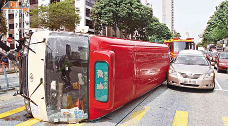 小巴翻側橫倒路中，差一點壓中鄰線私家車。	（蔡高華攝）