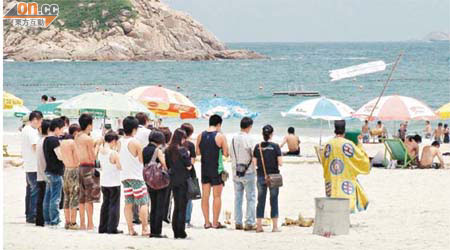 大批親友到海灘拜祭，神情哀傷。	（陳錦昌攝）