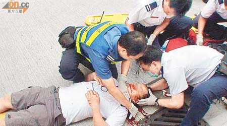 救護員為受傷男途人急救。（吳子生攝）