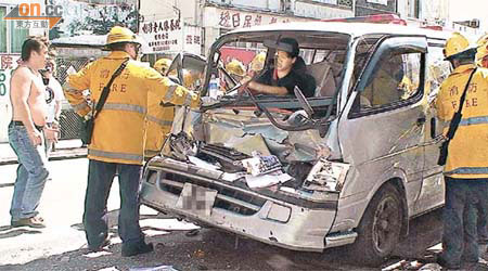 新牌司機被夾困車內，由消防員拯救，其父（左）在旁焦急不已。	（趙瑞麟攝）