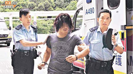涉嫌干擾車輛及襲警的南亞裔男子，由警員押送醫院治療。	（郭錦良攝）