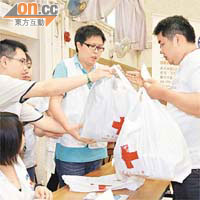 紅十字會人員向受災村民派發日用品。	（李健瑜攝）