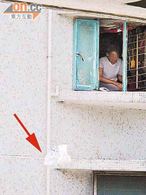 德田邨<br>長者屋疑有拾荒住戶收集垃圾後，隨手將膠袋（箭嘴示）拋出窗外。