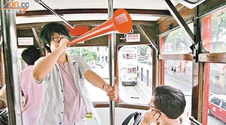 抗議人士在電車上層吹起Vuvuzela喇叭，吸引途人注目。	（高嘉業攝）