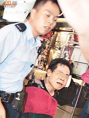 涉嫌盜竊的男子受傷，由警員押往醫院。	（陳桂健攝）