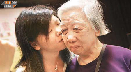 五十歲以下組別冠軍<BR>黃雅麗的奶奶（右）再次憶起情書內容，禁不住落淚，獲孫女獻吻安慰。	（高嘉業攝）