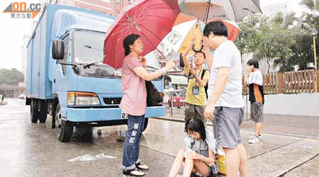 熱心夫婦為受傷女童打傘擋雨。	（蘇仲賢攝）