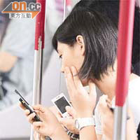地鐵車廂內常見乘客在玩手機。