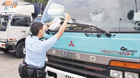 警員在貨車遭連環擊破擋風玻璃現場調查。	（吳子生攝）