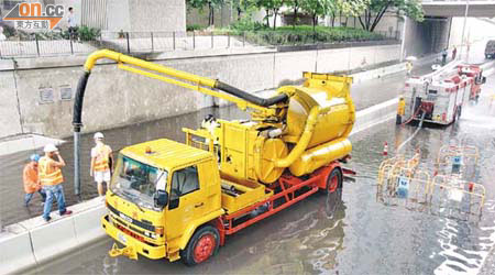 路政署派員清理青山公路的淤泥和積水。	（黃君堡攝）