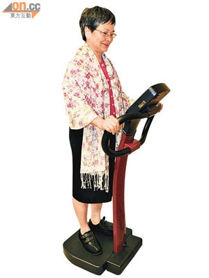 羅婆婆穿着防跌鞋站在俗稱「震震機」的高頻低幅互動負重運動儀。