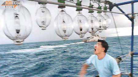 黃錫麟在保釣船上向日方攔截艦艇掟玻璃樽抗議。（中華保釣協會提供）