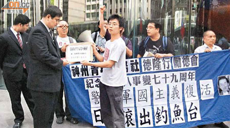 神州青年服務社代表（右）向日本駐港總領事館代表遞交請願信。