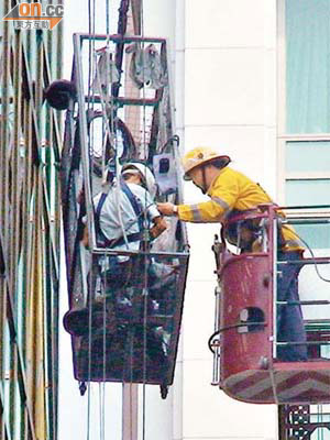 消防員升起雲梯將吊船上兩名工人救下。（許錦雄攝）