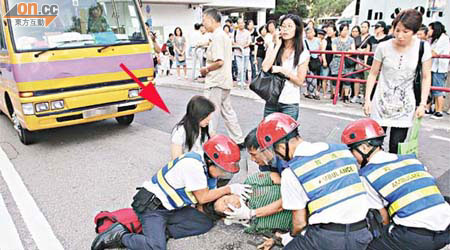 男子被保母車撞傷倒地，一名女親友（箭嘴示）趕至激動哭泣。	（黃君堡攝）