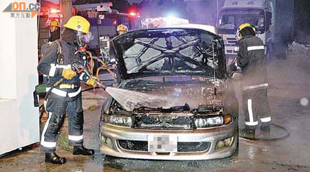 元朗<br>私家車車頭冒煙，消防員開喉灌救。（張曉楠攝）