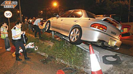 跑車失事剷上防撞欄，車身傾側。（周宏杰攝）