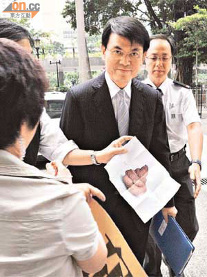 邱騰華昨日離開立法會時，遭地區人士送上印有糞便的紙張抗議。