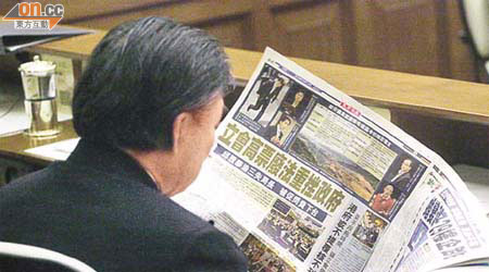 喺特首答問大會上，霍震霆埋頭看《東方日報》有關廢令嘅新聞。	（何天成攝）