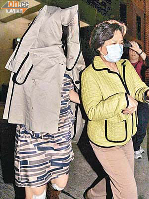 日籍女事主（左）當日脫險後，以衣服蒙頭協助警方調查。	