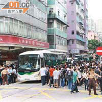 大批乘客走出馬路搶搭接駁巴士，導致出現人車爭路的驚險場面。	（蕭添榮攝）