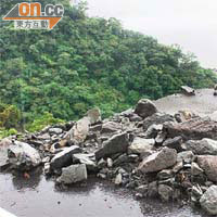 公路路面斷裂成懸崖，滿布大石。