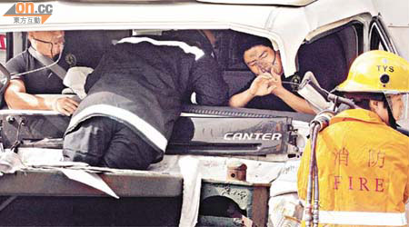 消防員拯救被困車內的司機及跟車工人。	（曾紹良攝）