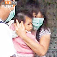在深水埗被門罅夾傷手的女童由母親抱着送院。	（蕭添榮攝）