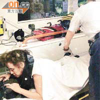 女子接受拔火罐治療時被燒傷，伏在救護車上接受急救。	（周亮恒攝）