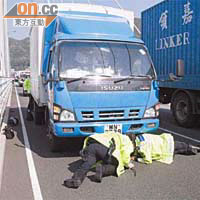 交通警員查看輾過女事主的輕型貨車底。