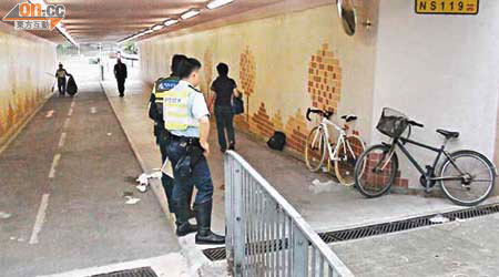 兩輛相撞的單車泊在隧道內，警員在場調查。	（翁火攝）