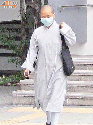 女被告馬惠鸞昨日認罪後，戴上口罩急步離開法院。