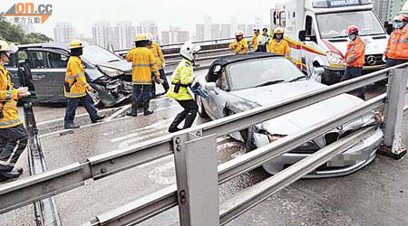 跑車及七人車在斜路迎頭相撞後同橫亘路中。	（左錦鴻攝）