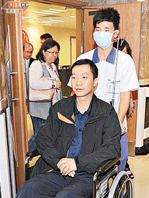 許細文在家人陪同下由輪椅推出病房。