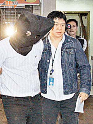 涉騙案的台灣男子被探員拘捕。	（陳桂建攝）