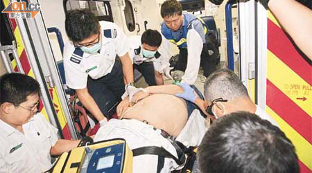 多名救護員合力將體重逾三百磅昏迷男子送院救治。	（林振華攝）