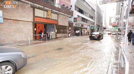 現場行人路遍布沙泥，馬路浸滿積水。	（李國健攝）