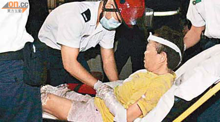 受傷婦人由救護員送院治理。	（高偉明攝）