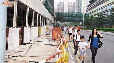 港鐵將軍澳站A出口工程，導致行人通道收窄，不少居民走出馬路，險象環生。（讀者提供圖片） 