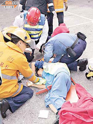 消防員由車底將女工救出，即場進行急救。	（左錦鴻攝）