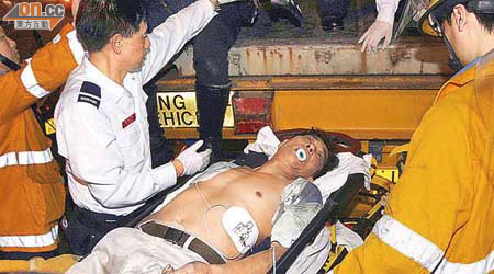 在貨櫃車上卸貨時昏迷的工人由消防員救下，送院搶救。	(劉子文攝)