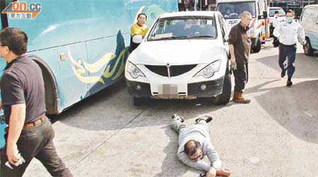 受傷旅遊巴司機倒臥地上。	（林少兒攝）
